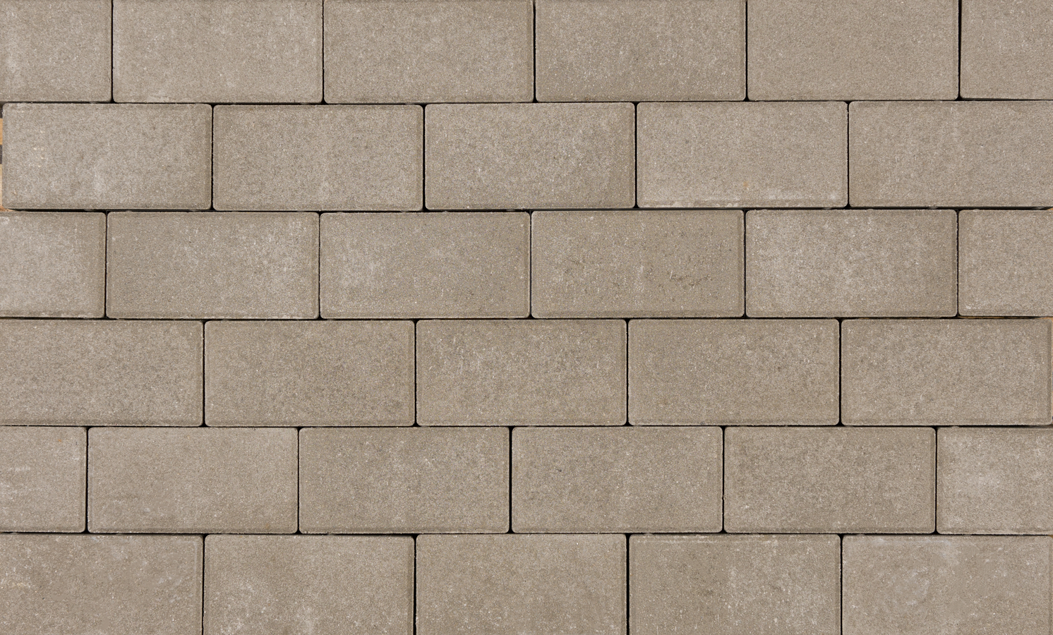 Betonstraatsteen met een natuursteenlook, rechthoekig van vorm, met een licht ruwe textuur. De afbeelding toont de steen in een neutrale belichting, geschikt voor gebruik in bestrating.