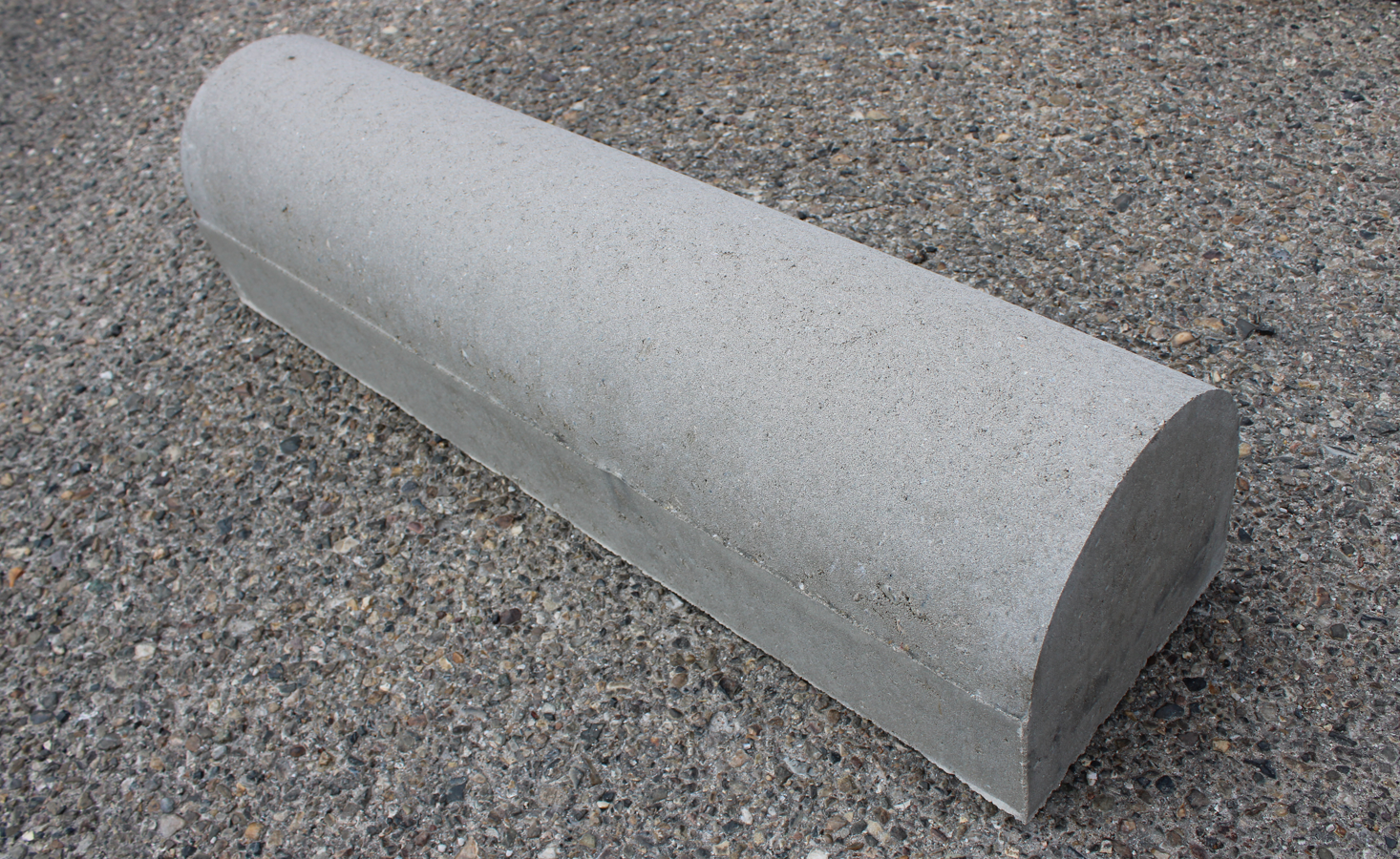 Betonnen parkeerstootband, gebruikt als fysieke begrenzing tussen parkeerplaatsen of aan de kopse kant van parkeervakken.